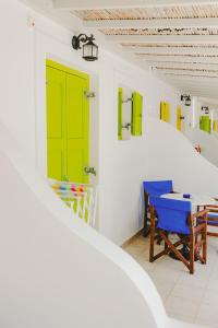 a room with green doors and a table and chairs at Gerani Studios in Astypalaia