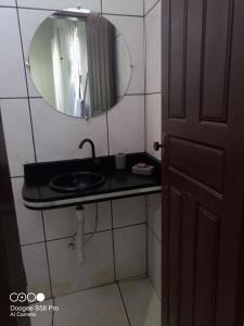 a bathroom with a sink and a mirror at Pousada Recanto do Mar in Tutóia