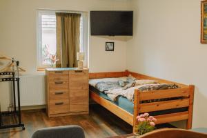 a bedroom with a bed and a dresser and a window at Teodor Apartman in Gyula