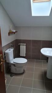 a bathroom with a toilet and a sink at El ático de Marinuca in Villabáñez