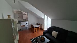 VillabáñezにあるEl ático de Marinucaのソファとキッチンのあるリビングルーム