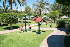 a park with a playground with slides and swings at Fantastico estudio en Benalbeach con vistas al mar in Benalmádena