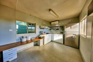 a large kitchen with white cabinets and a counter at KUR-Cow farm escape 35 minutes from Cairns in Kuranda