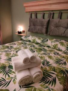 een slaapkamer met een bed met handdoeken erop bij Residenze del Bosco - Olivo in Tuscania
