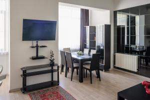 ein Wohnzimmer mit einem Tisch und Stühlen sowie einem TV in der Unterkunft Cozy studio, Center, Sea view in Baku
