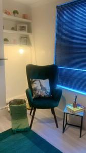 a living room with a green chair and a table at Aqua Suite in Gillingham