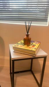 a table with two books and a vase on it at Aqua Suite in Gillingham