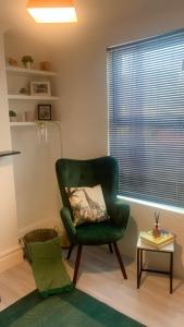a living room with a green chair and a table at Aqua Suite in Gillingham