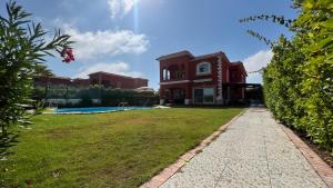 ein großes rotes Haus mit Hof und Pool in der Unterkunft Caribiano villa-3 in Dawwār Ḩalīs