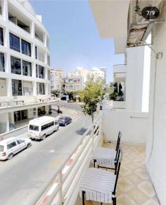 een balkon met 2 stoelen en een straat met auto's bij Big apt near sea best position tlv in Tel Aviv