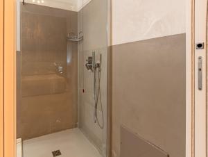 La salle de bains est pourvue d'une douche et d'une porte en verre. dans l'établissement Flower Rooms Cagliari, à Cagliari