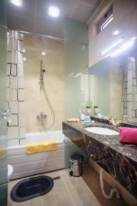 a bathroom with a sink and a shower and a tub at Cozy studio, Center, Sea view in Baku