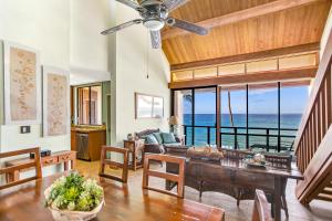a living room with a table and a view of the ocean at Unique Oceanfront Condo with AC- Alekona Kauai in Koloa
