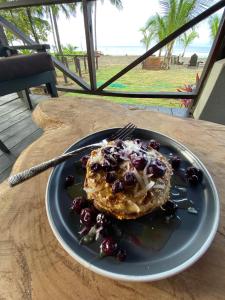 einen Teller mit einem Pfannkuchen mit Beeren auf dem Tisch in der Unterkunft Casa Morrillo in Morrillo