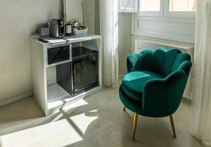 - un fauteuil vert dans le salon avec cheminée dans l'établissement Flower Rooms Cagliari, à Cagliari