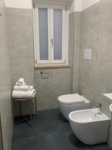 a bathroom with a white toilet and a sink at DomusEli in Santa Maria di Castellabate
