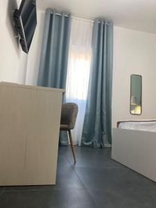 a bedroom with a bed and a desk and a television at DomusEli in Santa Maria di Castellabate