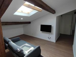a living room with a couch and a flat screen tv at LOFT CONFORTABLE in Vitry-sur-Seine