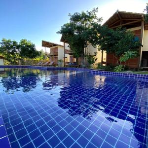 a blue tile swimming pool in front of a house at Barra Grande Bangalôs in Marau