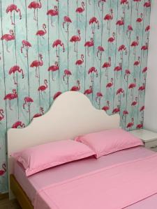 um quarto com um papel de parede de flamingo rosa em Casa de la Playa em Shkodër