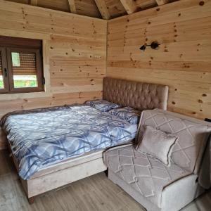 un letto e un divano in una baita di tronchi di Bosaca a Žabljak