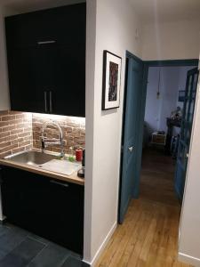 cocina con fregadero y puerta azul en Superbe appartement moderne et lumineux à Puteaux!, en Puteaux