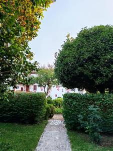 a path in a garden with a house in the background at Quinta da Maínha - Charming Houses in Braga