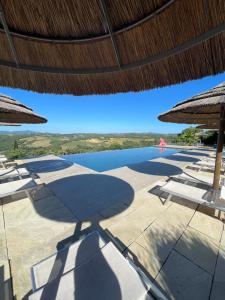 - une vue sur la piscine avec des parasols et l'eau dans l'établissement Country House Art and Garden, à Monte Antico