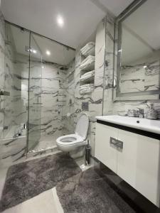 uma casa de banho com um WC, um lavatório e um chuveiro em Super appartement moderne neuf em Marrakech