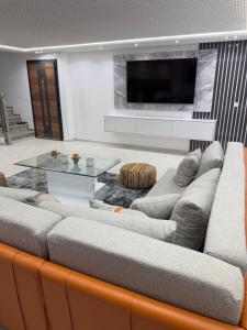 uma sala de estar com um sofá e uma televisão de ecrã plano em Super appartement moderne neuf em Marrakech