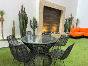uma mesa de vidro e cadeiras numa sala de estar com um sofá em Super appartement moderne neuf em Marrakech