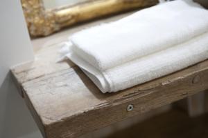 a stack of white towels on a wooden table at La Casetta in Tarquinia +21 photos