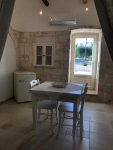 a kitchen with a table and chairs and a window at TRULLI LE 2 NICCHIE in Locorotondo