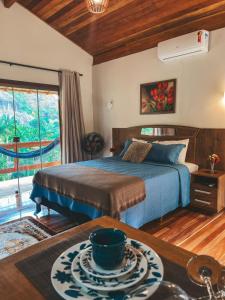 Un dormitorio con una cama y una mesa con un tazón. en Chalés Vale das Pedras en Venda Nova do Imigrante
