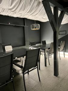 ein Esszimmer mit einem Tisch, Stühlen und einem Baum in der Unterkunft Golden House in Osijek