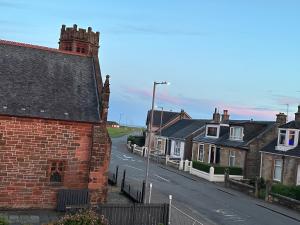 una calle vacía en un pueblo con casas en Seaside Home en Ardeer Square