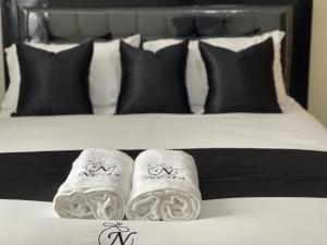 a bed with two towels on a bed with black pillows at Oak Nest 306 in Kericho