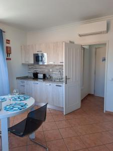 a kitchen with a table and a white table and chairs at Lovely new House - Guests Apartments in Olhão