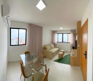 a living room with a couch and a table and chairs at Apto Corais do Mar 290m Praia Jatiuca in Maceió