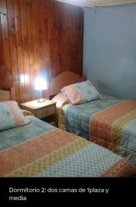 Zimmer mit 2 Betten und einer Lampe auf einem Tisch in der Unterkunft La estancia en la Isla in Isla Negra