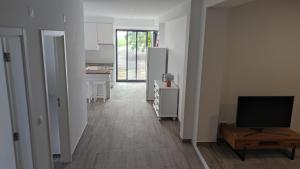 a living room with a television and a kitchen at Costa do Moinho in Horta