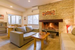 sala de estar con sofá y chimenea en Cabanas Luces el Bosque en Mar de las Pampas