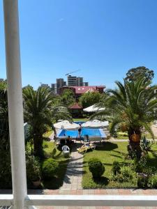 a view of a resort with palm trees and umbrellas at Guest House Nia in Gonio