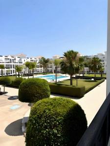 um resort com piscina, árvores e edifícios em Nouveau Appartement Familiale - Résidence Calme em Saidia 