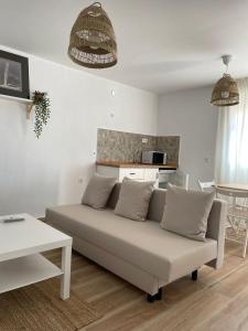 ein Wohnzimmer mit einem Sofa und einem Tisch in der Unterkunft Habitaciones Turísticas - La Tarayuela in Barbate