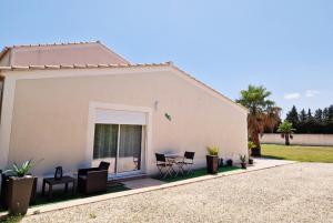 a white house with chairs and a patio at Le studio du bonheur in Orange