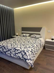 una camera da letto con un letto con un piumone bianco e nero di Casas da Veiga a Braga Altre 9 foto