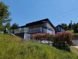 una casa sul fianco di una collina con dei fiori di Kuca za odmor BARE vacation house a Hadžići