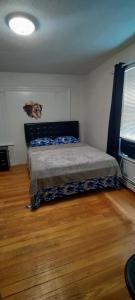 a bed in a bedroom with a wooden floor at Cozy, spacious and peaceful in Providence
