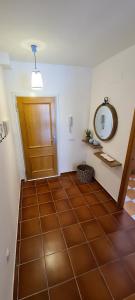 a hallway with a brown tiled floor with a wooden door at Siente el relax. in Alcossebre